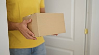 Genç Latin adam evde paket alıyor.