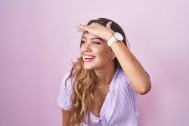 Pembe arka planda duran genç İspanyol kadın çok mutlu ve gülümsüyor. arama kavramı. 