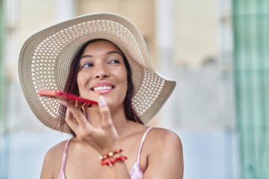 Young beautiful hispanic woman tourist smiling confident talking on smartphone at street