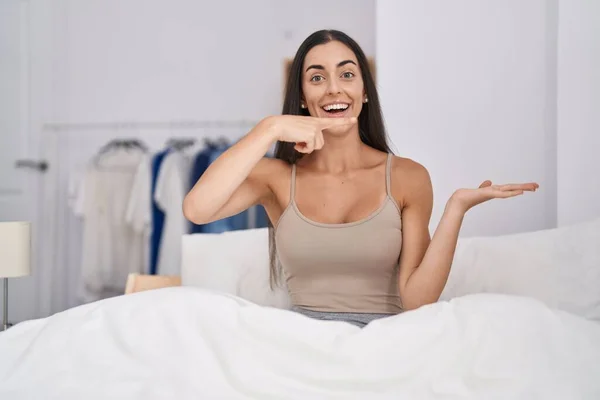 Young Brunette Woman Bed Home Amazed Smiling Camera While Presenting — Stock Photo, Image