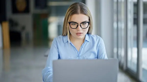 Young blonde woman business worker using laptop working at office