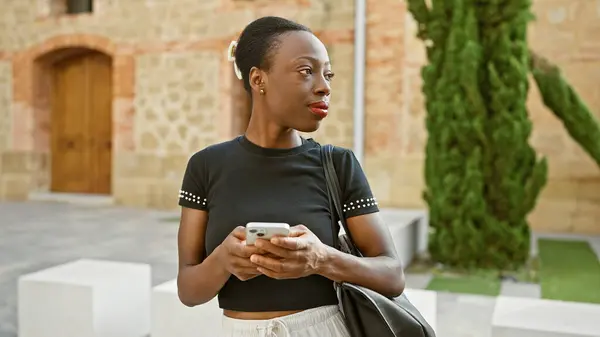 Африканская Американка Использует Смартфон Серьезным Выражением Лица Парке — стоковое фото