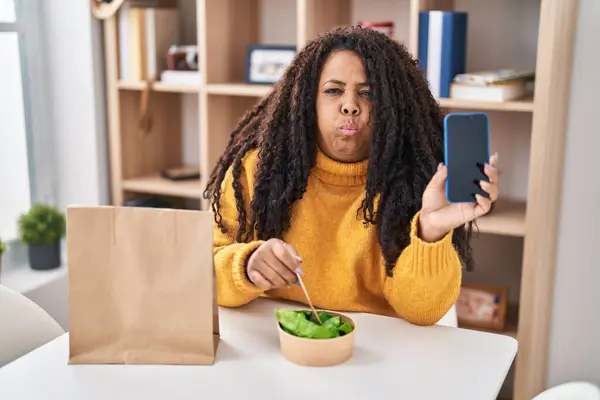 Size Hispanic Woman Eating Take Away Salad Holding Smartphone Puffing — Stock Photo, Image