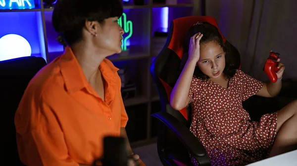 Mother-daughter streamer duo stressed while streaming video game in gaming room, showcasing a family gaming night gone awry