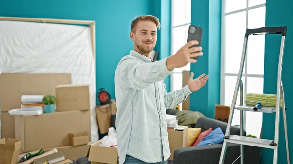 Young caucasian man having video call smiling at new home