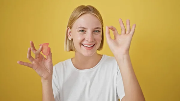 Junge Blonde Frau Mit Menstruationstasse Macht Geste Vor Isoliertem Gelben — Stockfoto