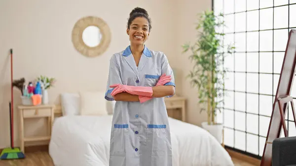 African american woman clean professional standing with arms crossed gesture smiling at hotel room