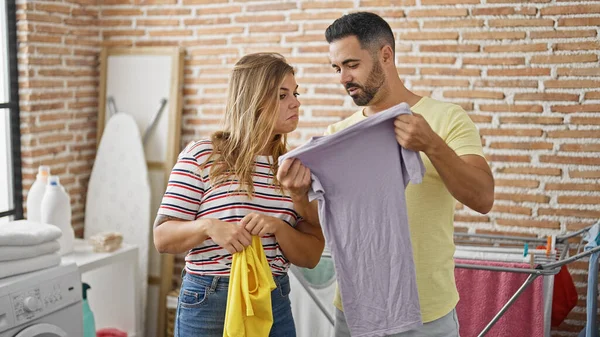 Man and woman couple looking t shirts at laundry room