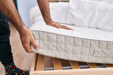 Yatak odasında döşek tutan Latin asıllı genç adam.