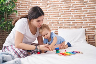 Anne ve oğlu yatak odasında oynuyorlar.