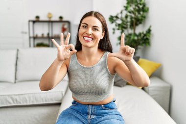 Genç ve güzel İspanyol kadın evdeki kanepede oturan sağırlarla iletişim kuruyor.