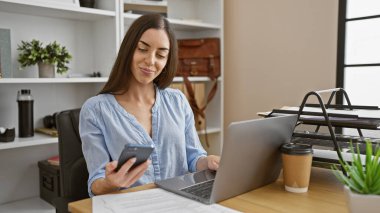 Çekici genç İspanyol kadın başarıya daldı, akıllı telefonuyla mesaj attı, bilgisayarına iş mesajları yazdı, ofiste güzel patronluk tasladı.
