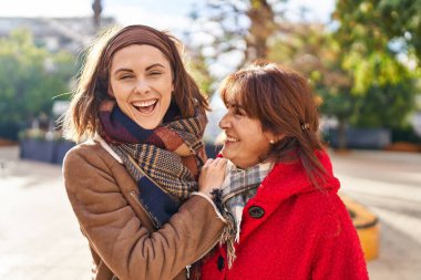 Two women mother and daughter hugging each other at park