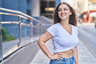 Young blonde woman smiling confident looking to the side at street