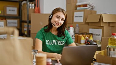 Yardım merkezinde gülümseyen dizüstü bilgisayar ve kulaklık kullanan genç bir kadın.