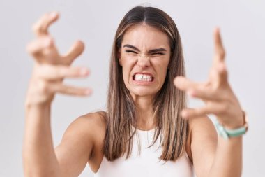 Beyaz arka planda duran Latin kökenli genç bir kadın öfkeden kudurmuş, elleri boğazlamaya çalışıyor, deli gibi bağırıyor. 