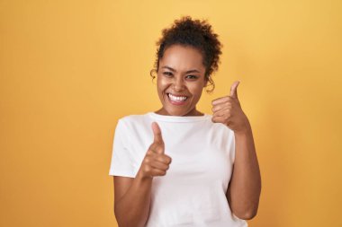 Sarı arka planda duran kıvırcık saçlı genç İspanyol kadın gülümsüyor telefonda konuşuyor ve seni işaret ediyor. Ara beni.. 