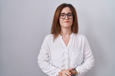 Esmer kadın, izole edilmiş beyaz arka planda el ele tutuşmuş ve gülümseyen rahat ve neşeli parmaklar üzerinde duruyordu. Başarı ve iyimserlik 