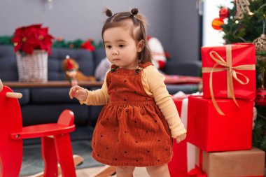 Sevimli Çinli çocuk evde Noel ağacının yanında duruyor.