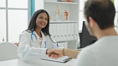 Doktor ve hasta klinikte el sıkışıyorlar.