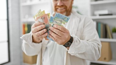 Cheerful caucasian business man confidently counting australian dollars at office, radiating success and happiness clipart