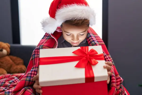愛らしいヒスパニックの少年は 自宅でソファーに座ってクリスマスの贈り物を荷を解く — ストック写真