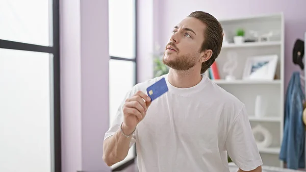 Ung Latinamerikansk Man Med Kreditkort Tänker Hemma — Stockfoto