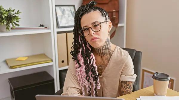 Confident, business-savvy hispanic amputee woman sitting intensely at desk in bustling office, the new face of modern working success