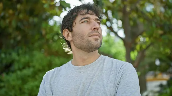 stock image Young man looking to the side with serious expression at the park