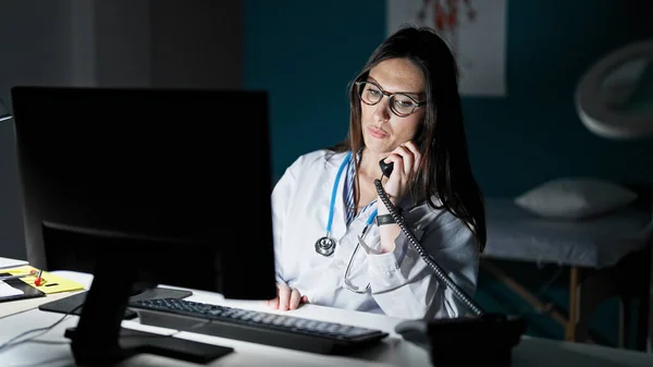 Młoda Piękna Latynoska Lekarka Rozmawiająca Przez Telefon Przez Komputer Klinice — Zdjęcie stockowe
