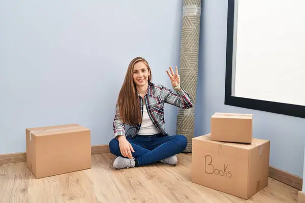 Young Blonde Woman Sitting Floor Moving New Home Showing Pointing — Stock Photo, Image
