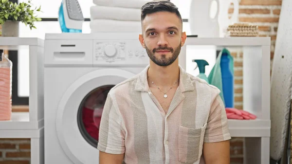 Ung Latinamerikansk Man Sitter Golvet Med Allvarligt Ansikte Tvättstugan — Stockfoto