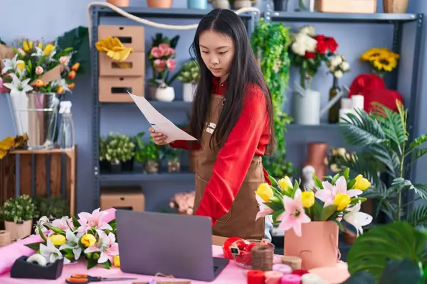 Young Chinese Woman Florist Using Laptop Reading Document Flower Shop - Stock-foto