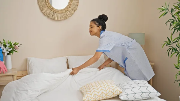 African american woman clean professional make bed at hotel room