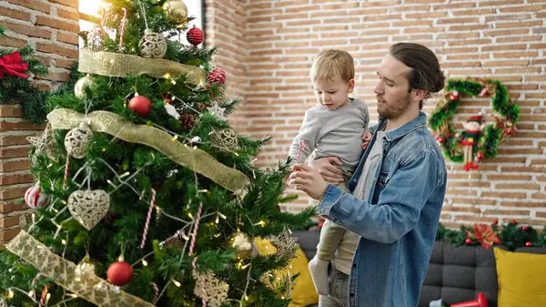 Father and son decorating christmas tree at home
