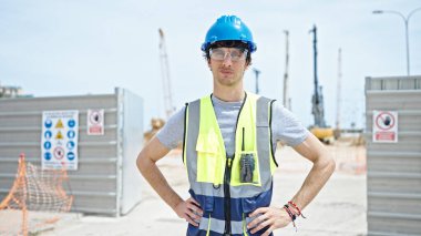 İspanyol asıllı genç bir mimar inşaat alanında ciddi bir yüzle duruyor.