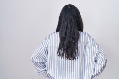 Gözlüklü genç İspanyol kadın kolları vücudunda geriye doğru bakıyor. 