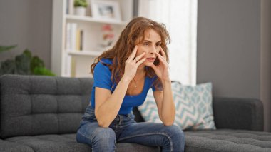 Evdeki kanepede oturan genç kadın strese girdi.