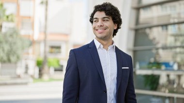 Sokakta kendine gülen genç Latin iş adamı