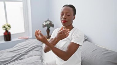 Afro-Amerikalı kadın yatakta yatıyor, kollarını kavuşturup kuşkucu ve gergin bir yüz ifadesi takınıyor. Onaylamayan bakış olumsuz titreşimleri yansıtır. Yatak odasındaki kötümser kişi.