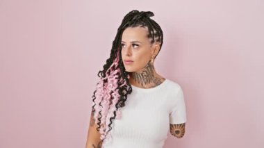 Kendine güveni tam bir İspanyol ampüte kadın. Kol saatinin geç saatlerine kadar kontrol ediyor. Pembe arka planda tek başına duruyor.