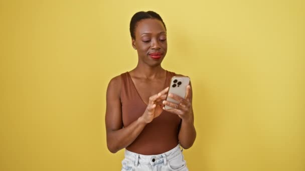 Χαρούμενη Αφροαμερικανή Που Γιορτάζει Νίκη Της Κινητό Της Απομονωμένο Κίτρινο — Αρχείο Βίντεο