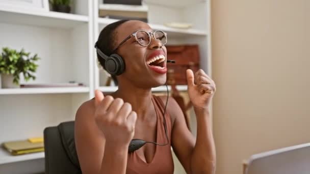 자신감 아프리카계 미국인 사무실에서 즐거운 제스처와 승리를 헤드셋을 그녀는 그녀의 — 비디오