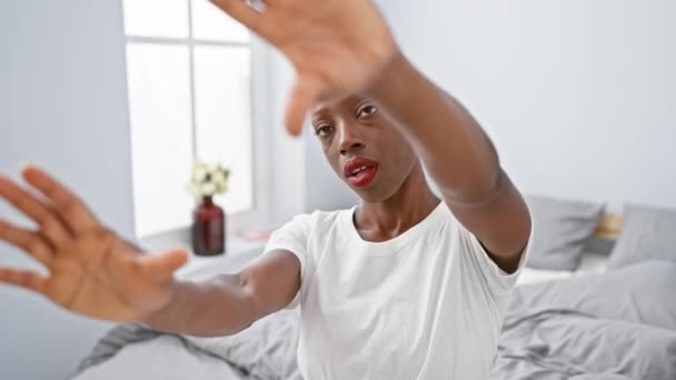 一个快乐 富有创造力的非洲裔美国女人躺在床上 用她的手和手指在舒适的卧室里捕捉到一个独特的身躯 这是相机的视角 — 图库视频影像