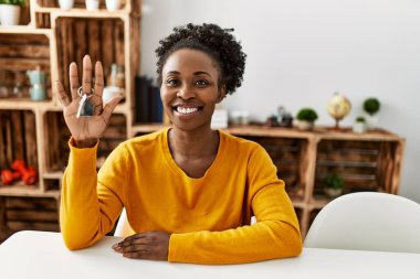 African american woman smiling confident holding key of new house at home