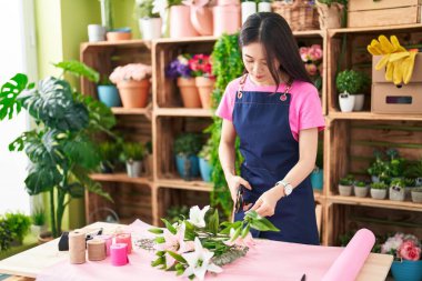Çiçekçinin sapını kesen genç Çinli kadın.
