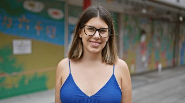 Neşeli, güzel, gözlüklü İspanyol kadın Nakamise Caddesi, Asakusa, Tokyo 'da kendine güvenen bir gülümsemeyle poz veriyor.