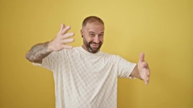 Genç adam kendine güveni tam sarı arka planda sarılıyor.