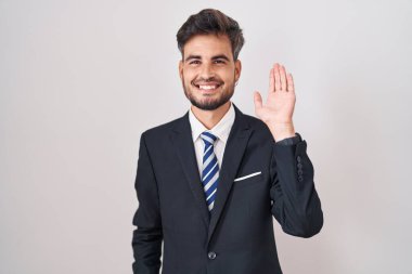 Dövmeli, takım elbiseli ve kravatlı genç İspanyol adam merhaba diyor mutlu, güler yüzlü, dostça bir jest. 