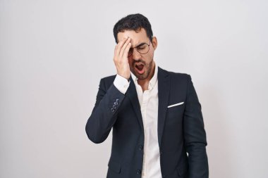 Beyaz arka planda duran yakışıklı İspanyol adam yarı yüzünü, gözünü ve ağzını eliyle kapatmaktan yorulmuş esniyor. Yüzüm acıyor.. 